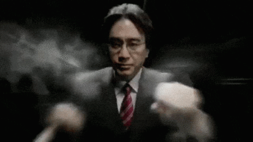 A Man In A Suit And Tie Is Standing In The Dark With His Arms Outstretched . GIF