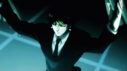 A Man In A Suit And Tie Is Standing In The Dark With His Arms Outstretched GIF