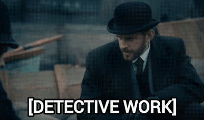 A Man In A Suit And Tie Is Standing Next To A Sign That Says Detective Work GIF