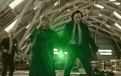 A Man In A Suit And Tie Is Standing Next To A Woman And A Man In A Suit GIF