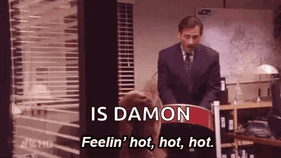 A Man In A Suit And Tie Is Standing Next To A Woman In A Chair And Talking To Her . GIF