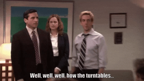 A Man In A Suit And Tie Is Standing Next To A Woman In A Suit And Tie And Says Well Well Well How The Turntables GIF