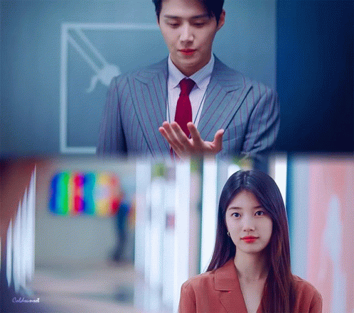 A Man In A Suit And Tie Is Standing Next To A Woman In A Suit GIF
