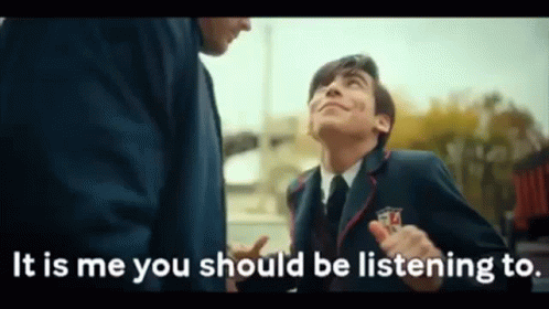 A Man In A Suit And Tie Is Standing Next To Another Man And Talking To Him . GIF