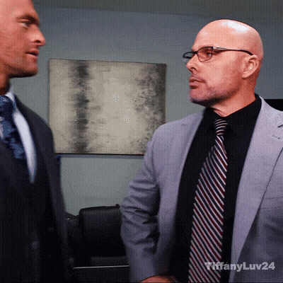 A Man In A Suit And Tie Is Standing Next To Another Man In A Suit GIF