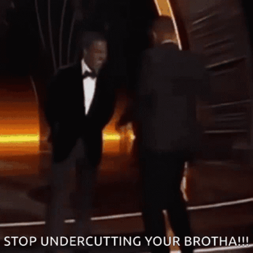 A Man In A Suit And Tie Is Standing Next To Another Man In A Suit And Tie And Says Stop Undercutting Your Brotha GIF