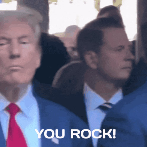 A Man In A Suit And Tie Is Standing Next To Another Man Who Says You Rock GIF