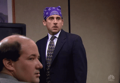 A Man In A Suit And Tie Is Standing Next To Another Man With A Nbc Logo On The Bottom Right GIF