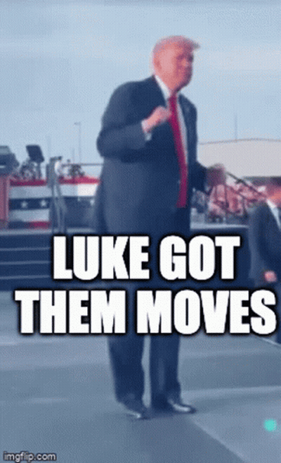 A Man In A Suit And Tie Is Standing On A Stage With The Caption Luke Got Them Moves GIF