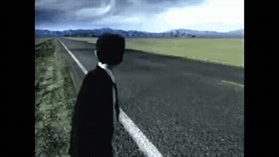 A Man In A Suit And Tie Is Standing On The Side Of A Road In The Middle Of A Field . GIF