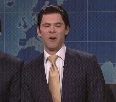 A Man In A Suit And Tie Is Standing With His Eyes Closed . GIF