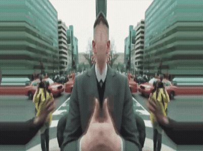 A Man In A Suit And Tie Is Surrounded By Buildings GIF
