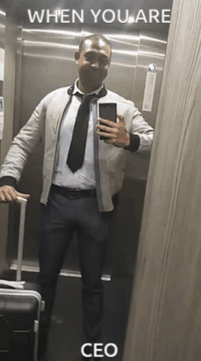 A Man In A Suit And Tie Is Taking A Selfie In An Elevator With The Caption When You Are Ceo . GIF