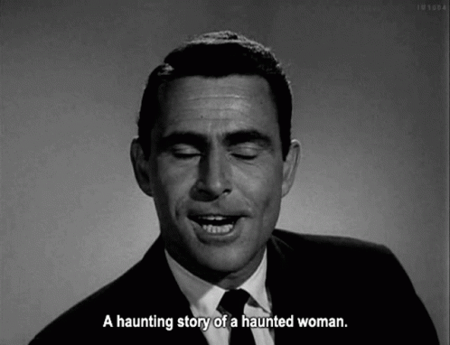 A Man In A Suit And Tie Is Talking About A Haunting Story Of A Haunted Woman . GIF