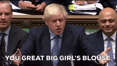 A Man In A Suit And Tie Is Talking Into A Microphone And Says " You Great Big Girl 'S Blouse " . GIF
