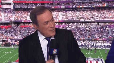 A Man In A Suit And Tie Is Talking Into A Microphone In Front Of A Football Stadium That Says National Football League GIF