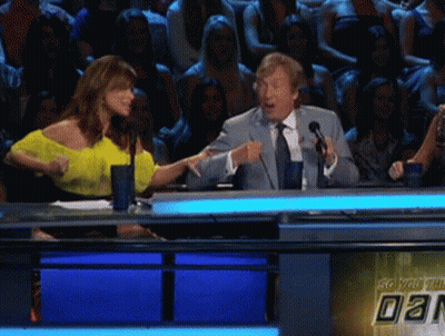 A Man In A Suit And Tie Is Talking Into A Microphone GIF