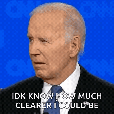 A Man In A Suit And Tie Is Talking Into A Microphone While Making A Funny Face . GIF
