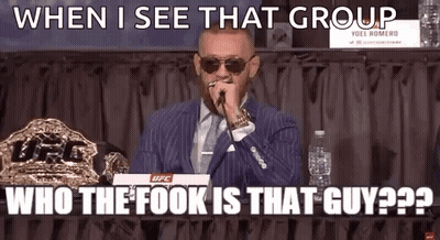 A Man In A Suit And Tie Is Talking Into A Microphone While Sitting At A Table . GIF