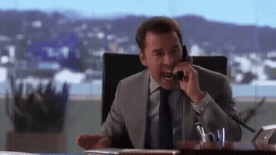 A Man In A Suit And Tie Is Talking On A Cell Phone . GIF