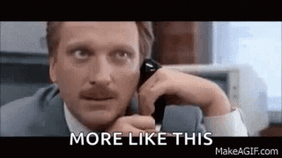 A Man In A Suit And Tie Is Talking On A Cell Phone And Saying `` More Like This '' . GIF