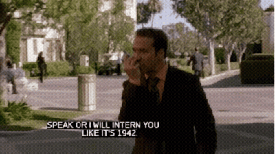A Man In A Suit And Tie Is Talking On A Cell Phone And Says Speak Or I Will Intern You Like It Is 1942 GIF