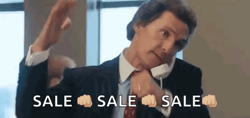 A Man In A Suit And Tie Is Talking On A Cell Phone While Making A Fist Gesture . GIF