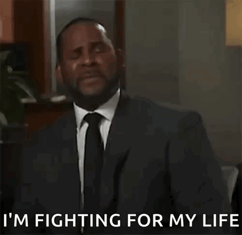 A Man In A Suit And Tie Is Talking On A Cell Phone . GIF