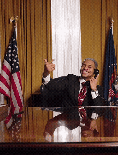 A Man In A Suit And Tie Is Talking On A Phone GIF