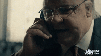 A Man In A Suit And Tie Is Talking On A Phone With The Words " The Loudest Voice " Behind Him GIF