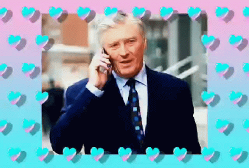 A Man In A Suit And Tie Is Talking On His Cell Phone GIF