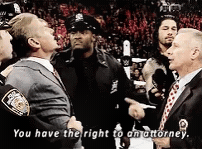 A Man In A Suit And Tie Is Talking To A Police Officer Who Says " You Have The Right To An Attorney " GIF