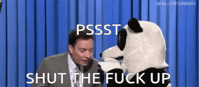 A Man In A Suit And Tie Is Talking To A Stuffed Panda Bear Who Is Saying Shut The Fuck Up GIF