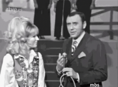 A Man In A Suit And Tie Is Talking To A Woman In A Black And White Photo . GIF