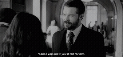 A Man In A Suit And Tie Is Talking To A Woman In A Hallway In A Black And White Photo . GIF
