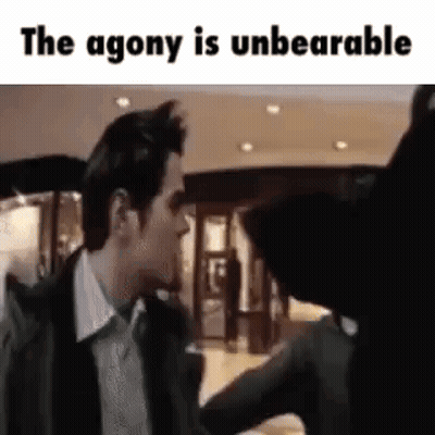 A Man In A Suit And Tie Is Talking To A Woman In A Store . GIF