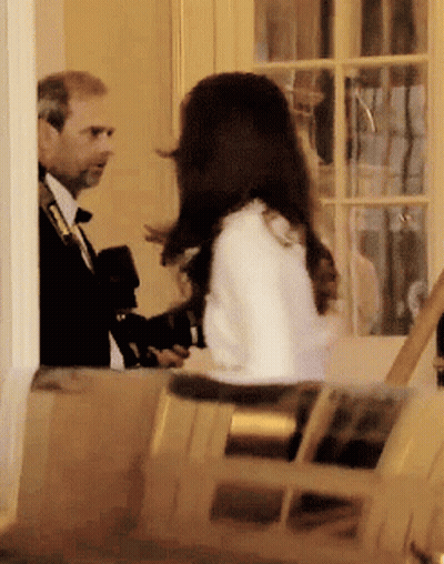 A Man In A Suit And Tie Is Talking To A Woman In A White Coat GIF