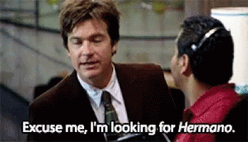 A Man In A Suit And Tie Is Talking To Another Man And Says Excuse Me I 'M Looking For Hermano GIF