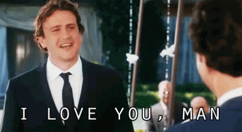 A Man In A Suit And Tie Is Talking To Another Man And Says I Love You Man . GIF