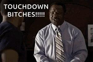 A Man In A Suit And Tie Is Talking To Another Man And Says Touchdown Bitches . GIF