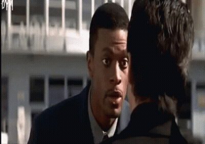 A Man In A Suit And Tie Is Talking To Another Man In A Black Suit GIF