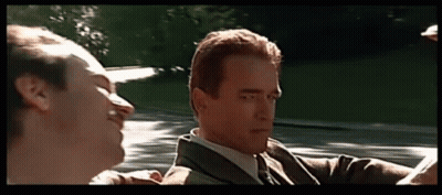 A Man In A Suit And Tie Is Talking To Another Man In A Convertible GIF