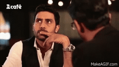 A Man In A Suit And Tie Is Talking To Another Man In A Restaurant . GIF