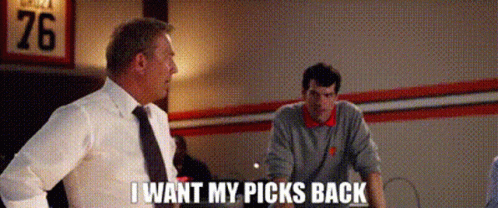 A Man In A Suit And Tie Is Talking To Another Man In A Room While Another Man Looks On . GIF