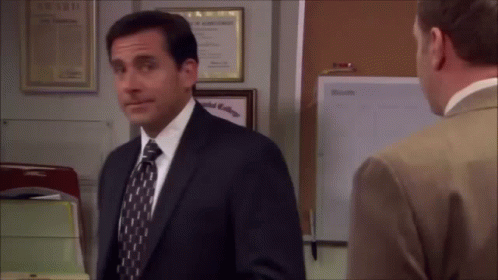 A Man In A Suit And Tie Is Talking To Another Man In An Office . GIF