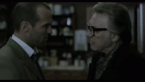 A Man In A Suit And Tie Is Talking To Another Man . GIF