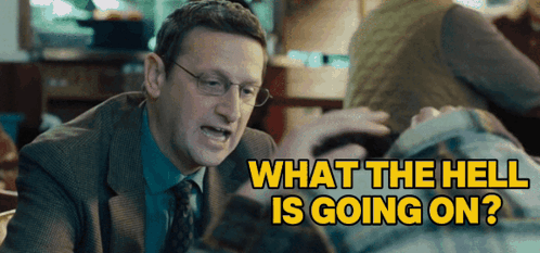 A Man In A Suit And Tie Is Talking To Another Man With The Words " What The Hell Is Going On " Behind Him GIF