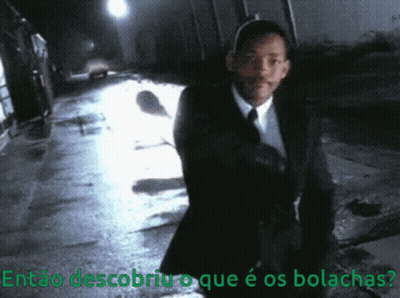 A Man In A Suit And Tie Is Walking Down A Dark Street With The Words Então Descobriu O Que É Os Bolachas GIF
