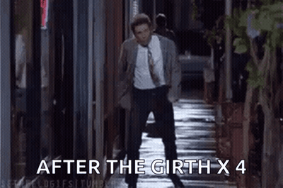 A Man In A Suit And Tie Is Walking Down A Sidewalk At Night . GIF