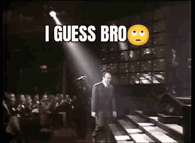 A Man In A Suit And Tie Is Walking Down A Staircase In Front Of A Crowd Of People . GIF